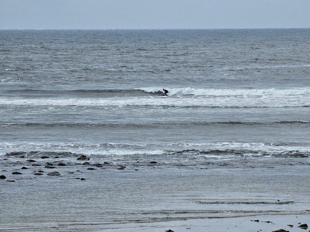 Surfer on a hip high wave in front of the shop
